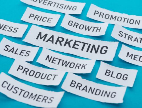 components of marketing on pieces of paper on blue